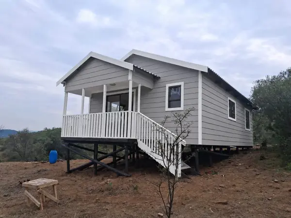Grey Nutec house on stilts with a front balcony