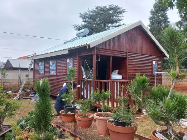 Red timber house with a planted garden in front