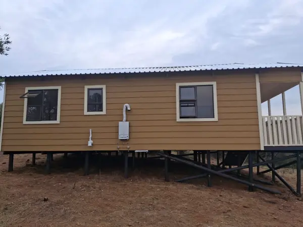 Tan Nutec house raised on a timber base with a side veranda