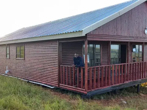 Dark timber log home with a long covered veranda