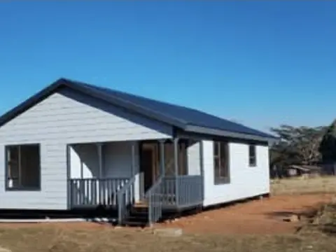 White Nutec house with dark roof and small front porch