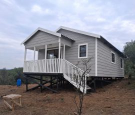 Elevated Nutec home with front deck and staircase by Mutsamvi Construction.