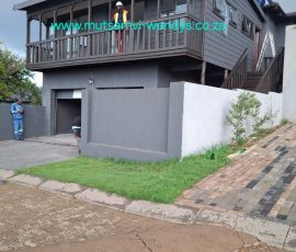 Contemporary Nutec home with covered veranda and raised deck by Mutsamvi Construction.