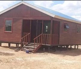 Custom-built wooden log cabin with front steps and covered entrance by Mutsamvi Construction.