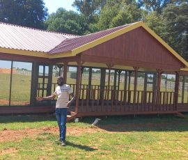 Custom-built wooden lodge with wraparound veranda by Mutsamvi Construction.
