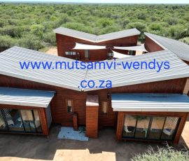 Modern wooden log home with covered veranda and durable timber cladding.