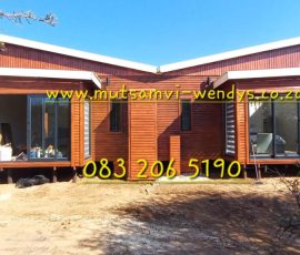 Luxury wooden log home with covered patio and quality finishes by Mutsamvi Construction.