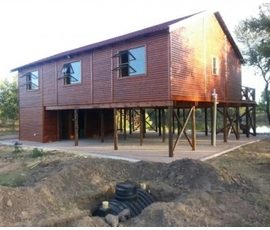 Raised timber log home with modern design built by Mutsamvi Construction.