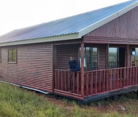Modern timber log home with front porch built by Mutsamvi Construction.