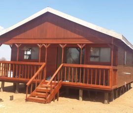 Modern timber log home with decorative veranda railings by Mutsamvi Construction.