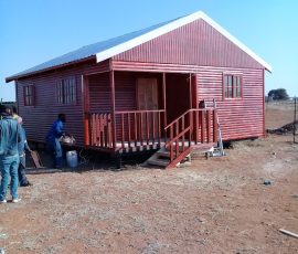 Custom-built wooden log home with covered veranda by Mutsamvi Construction.
