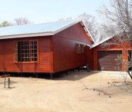 Custom-built timber log home with attached garage by Mutsamvi Construction.