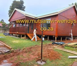 Modern custom-built log home with elevated veranda by Mutsamvi Construction.
